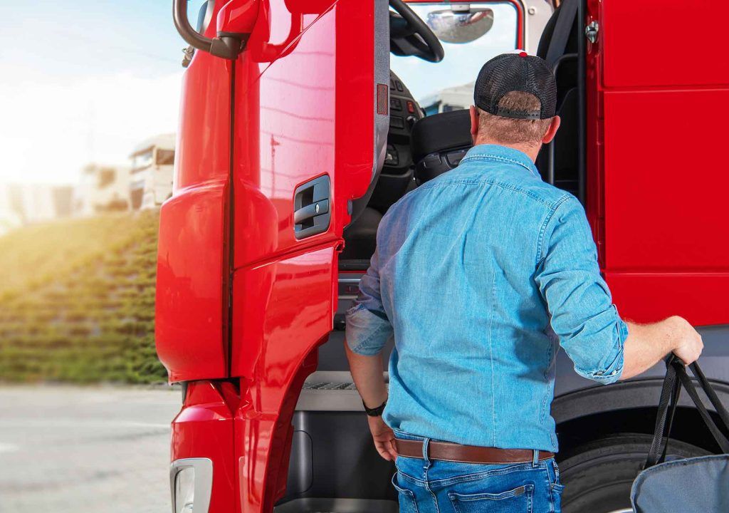 Chico subiéndose a su camión Autoescuela Hinarejos